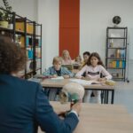 Children learn biology in a colorful classroom setting with a teacher explaining a skull model.