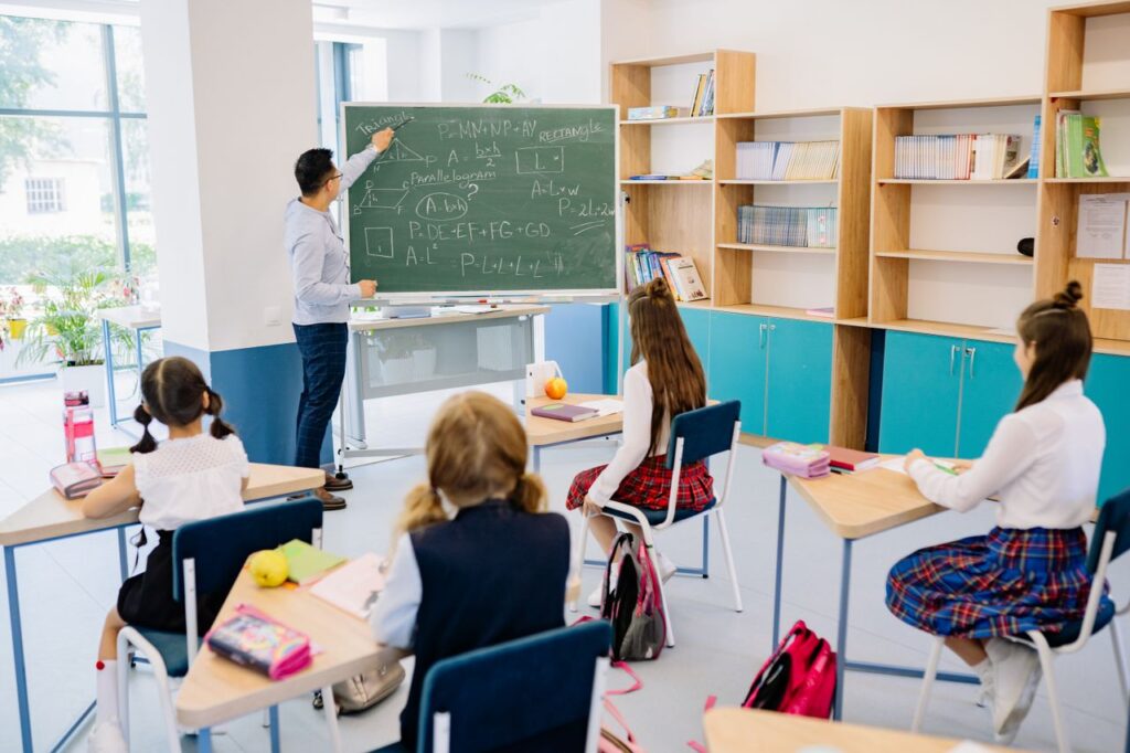 Children in a classroom focused on a math lesson with a teacher. Bright and educational atmosphere.